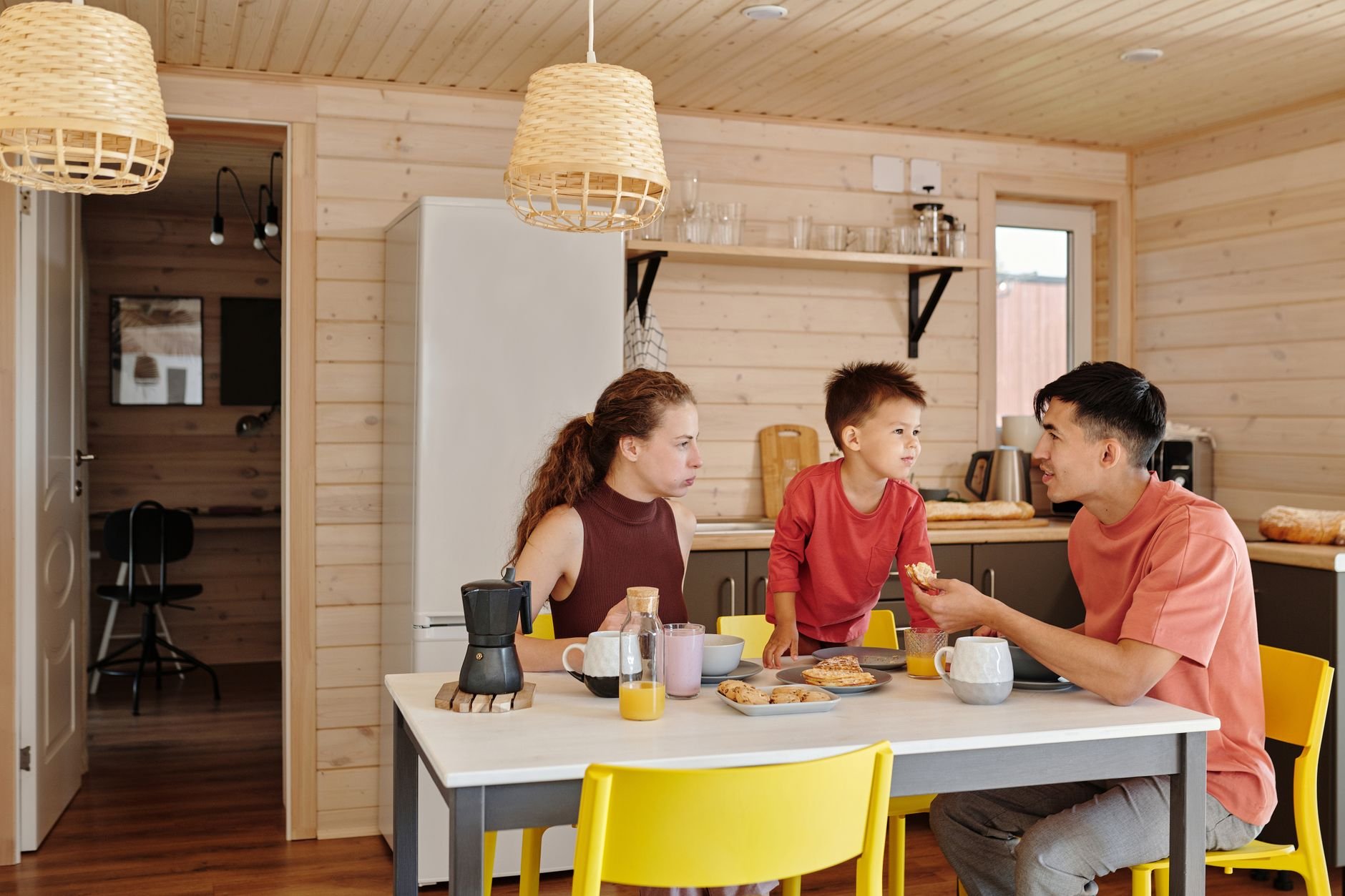 Happy family enjoying breakfast together in a cozy, modern kitchen — the moment a plan protects.